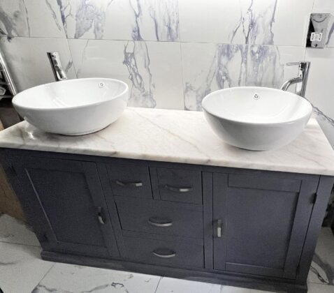 The elegant grey paint perfectly complementing the white marble top and basins